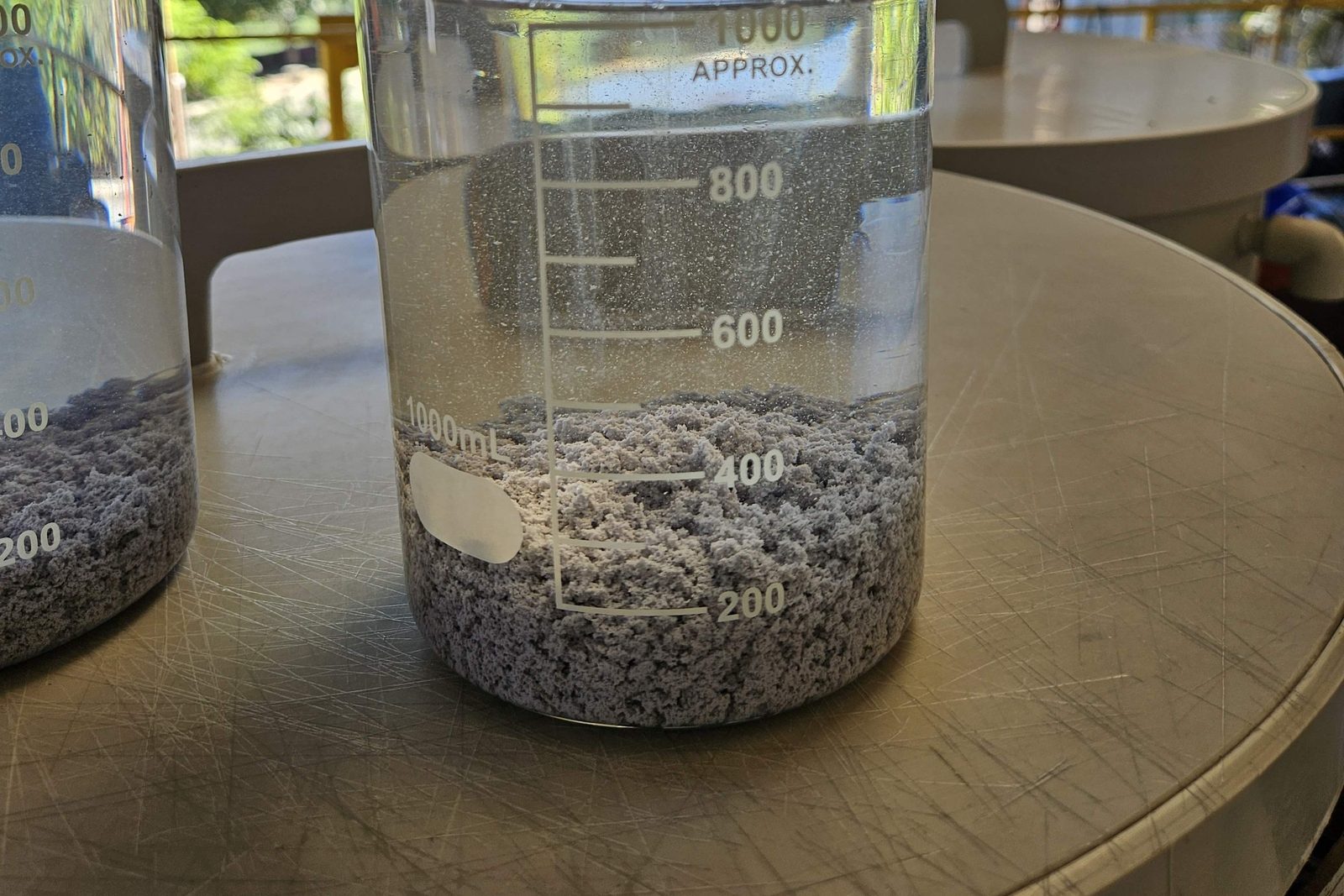 Béquer com flocos sedimentados após ensaio de floculação Béquer com flocos sedimentados após ensaio de floculação