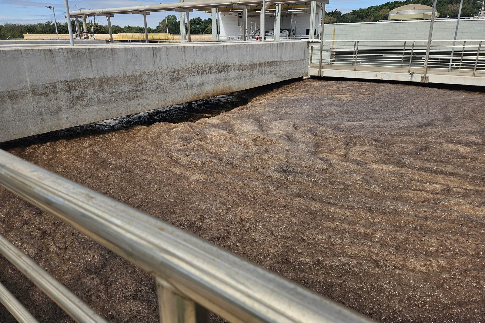 Espuma na superfície de tanque de aeração, vista da passarela Espuma na superfície de tanque de aeração, vista da passarela